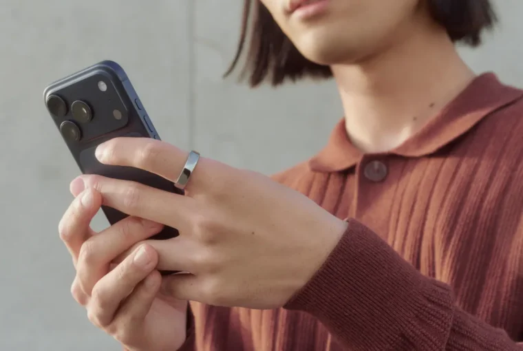 Woman wearing Oura Ring and looking at phone screen