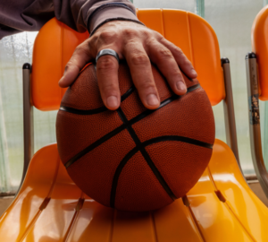 Man's hand holding basketball and wearing Oura Ring