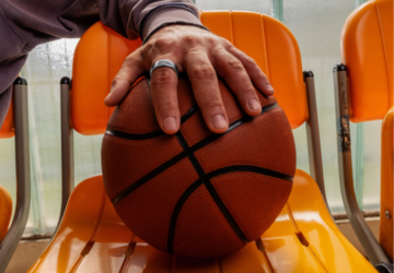 Man's hand holding basketball and wearing Oura Ring