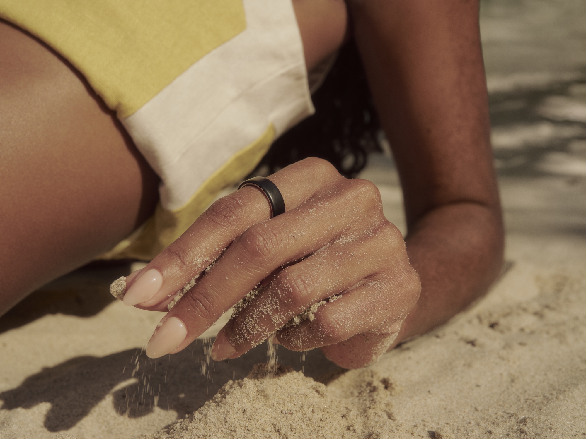 Woman wearing Oura Ring 5 at the beach | detail