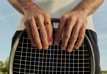 Man wearing Oura Ring 5 holding a tennis racket