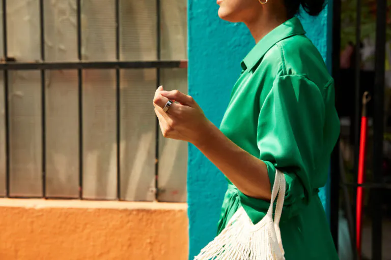 Woman in green dress carrying white bag