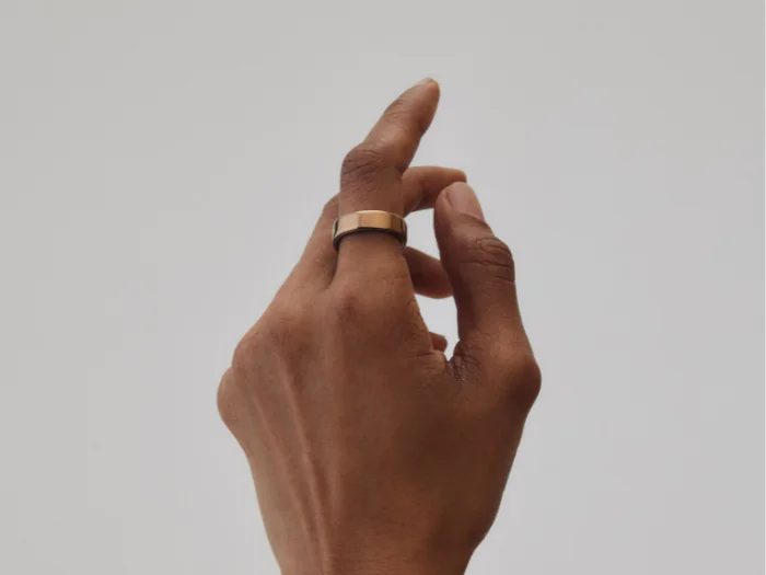A woman's hand wearing the Oura Ring 5