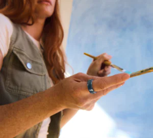 Woman painting wearing Oura Ring 4 Ceramic